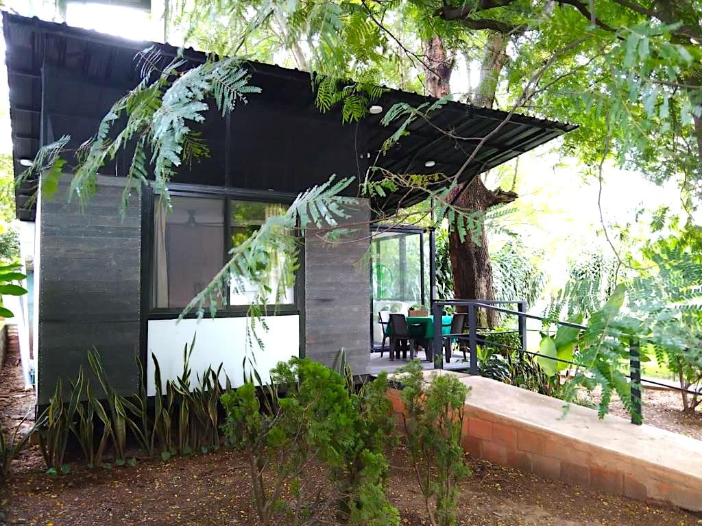 Fachada terminada de la cabaña Ray: alcoba, balcón y sala vistos desde el jardín